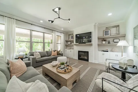 a living room with furniture fireplace and a large window