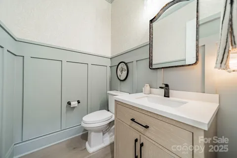 a bathroom with a sink a toilet and a mirror