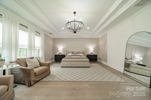 a spacious bedroom with a bed and a chandelier