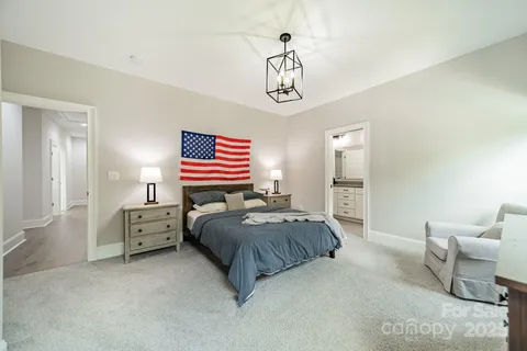 a bedroom with a bed a chandelier and a window