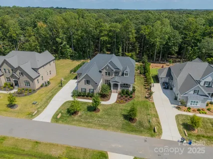 an aerial view of residential houses with outdoor space and trees
