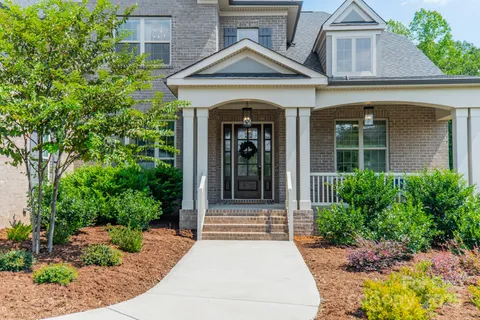 a view of a house with potted plants and a large window