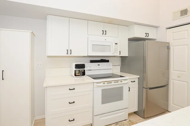 a kitchen with sink a mirror and cabinets