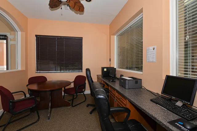 a view of swimming pool with a chair and palm trees