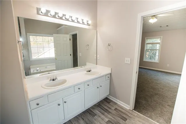 a bathroom with a double vanity sink and mirror with shower