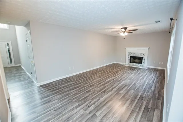 a view of empty room with wooden floor and fireplace