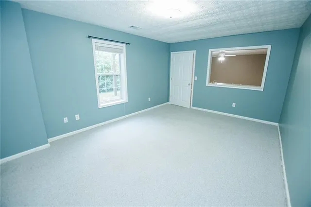 an empty room with windows and closet