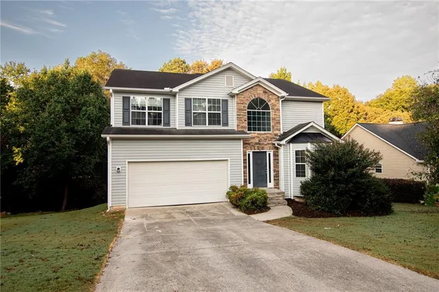 a front view of a house with a yard and garage