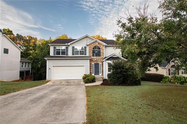 a front view of a house with a yard and garage