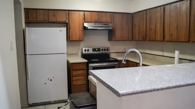 a kitchen with stainless steel appliances a stove refrigerator sink and cabinets