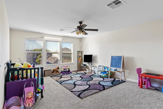 a living room with furniture and a ceiling fan