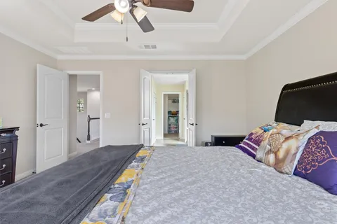 a bedroom with a bed and a ceiling fan