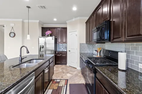 a kitchen with granite countertop stainless steel appliances and wooden cabinets