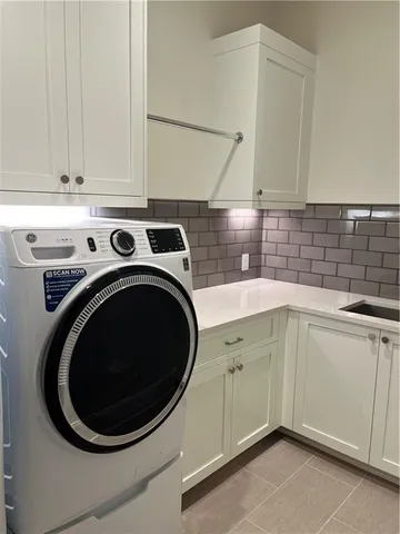 a utility room with sink dryer and washer