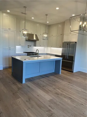 a large kitchen with stainless steel appliances granite countertop a sink a stove and a refrigerator