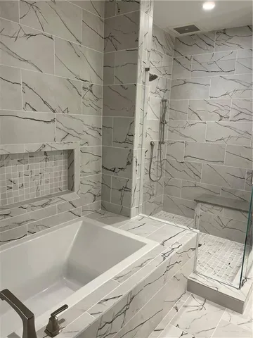 a bathroom with a bathtub and shower