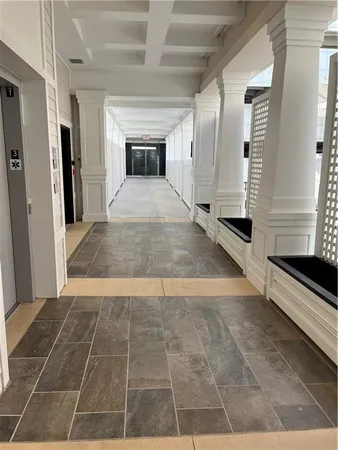 a view of a hall with wooden floor and a kitchen