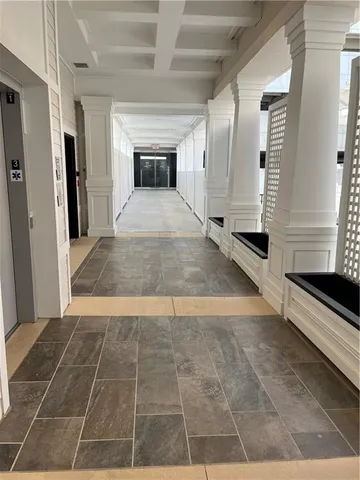 a view of a hall with wooden floor and a kitchen