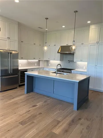 a kitchen with stainless steel appliances granite countertop a sink a stove and a refrigerator