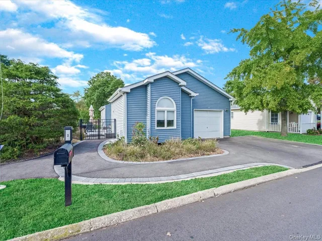 a view of a house with a yard and large tree