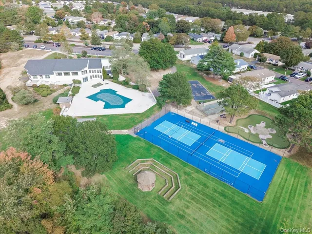 an aerial view of residential house with outdoor space and trees all around