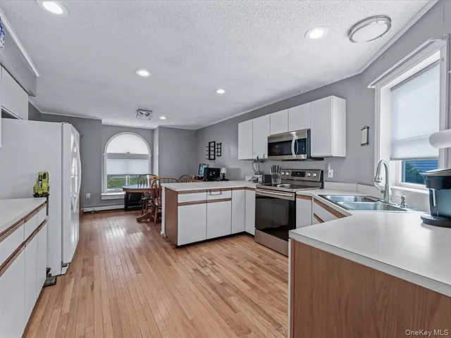 a kitchen with sink a microwave and cabinets