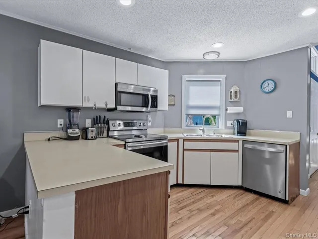 a kitchen with a sink a stove top oven and white kitchen