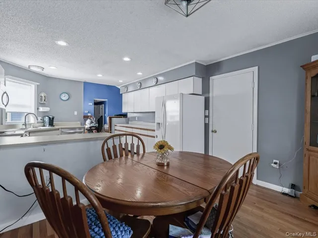 a kitchen with stainless steel appliances granite countertop a dining table and chairs