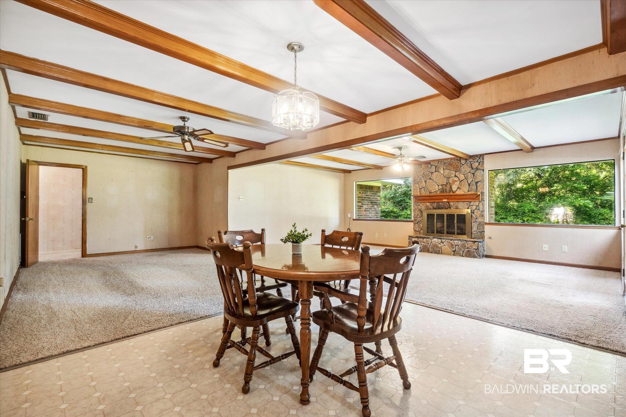 1252 Helm Circle Mobile, AL 36693 - Photo 7 of 18 Dining room with beamed ceiling, light tile patterned flooring, ceiling fan with notable chandelier, and a stone fireplace