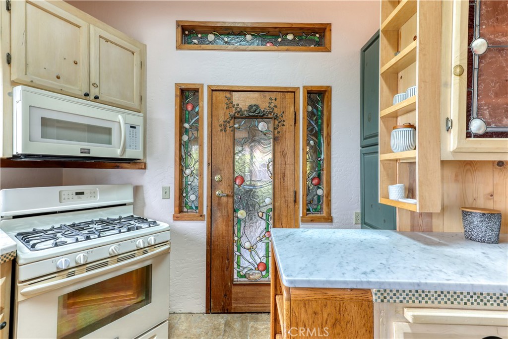 564 Croyden Lane Cambria, CA 93428 - Photo 9 of 64 a kitchen with stainless steel appliances granite countertop a stove and a microwave