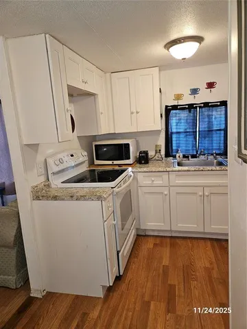 a utility room with wooden floor washer and dryer