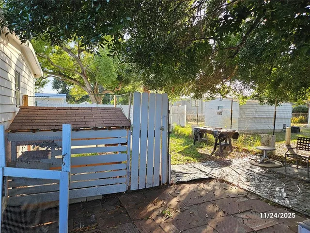 a view of a patio with table and chairs and a large tree