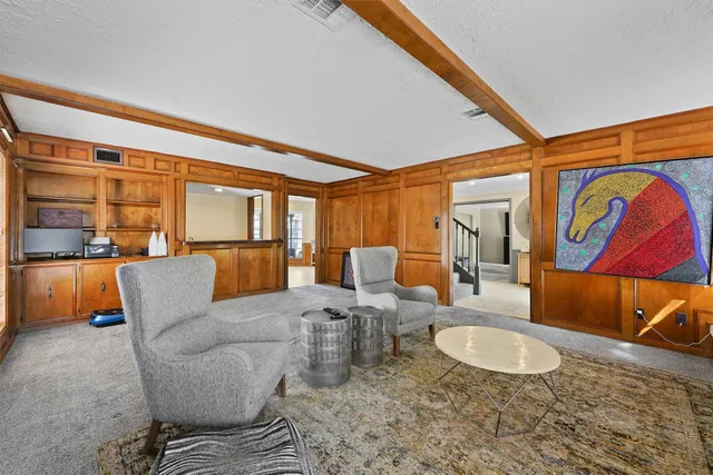 a living room with furniture a rug and kitchen view