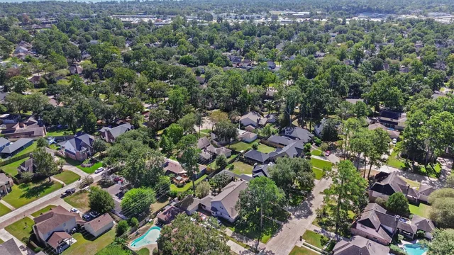 an aerial view of residential house with outdoor space and trees all around