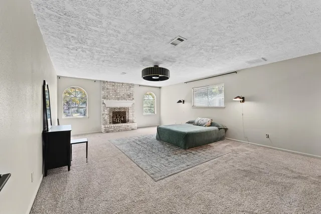 a spacious bedroom with a bed and a fireplace