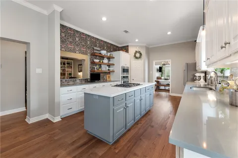 a large kitchen with stainless steel appliances a lot of counter space and wooden floor