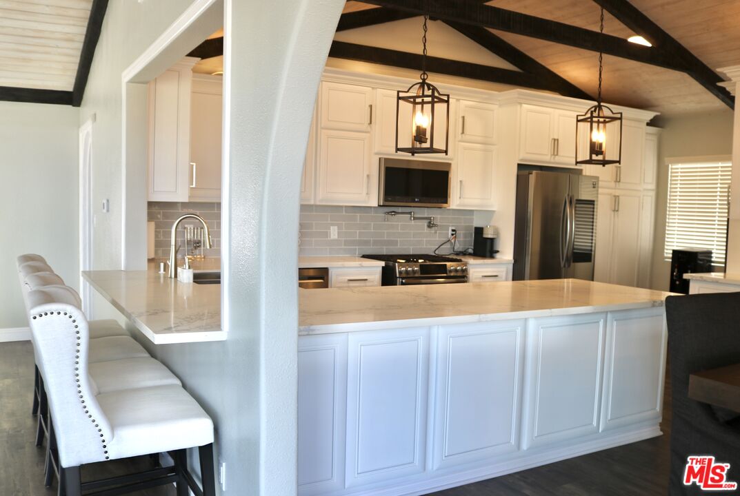 50 Rockinghorse Road Rancho Palos Verdes, CA 90275 - Photo 4 of 18 a very nice looking open kitchen with stainless steel appliances granite countertop a refrigerator a stove and a sink with wooden floor