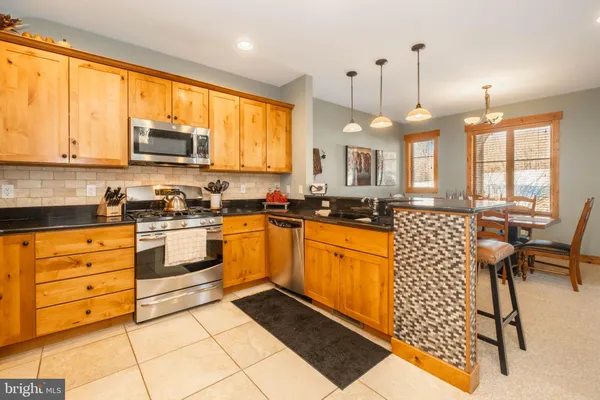 a large kitchen with kitchen island granite countertop a large window cabinets and a sink
