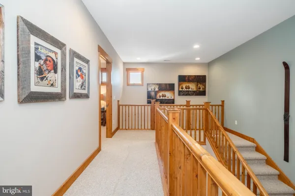a view of a hallway with wooden floor and staircase