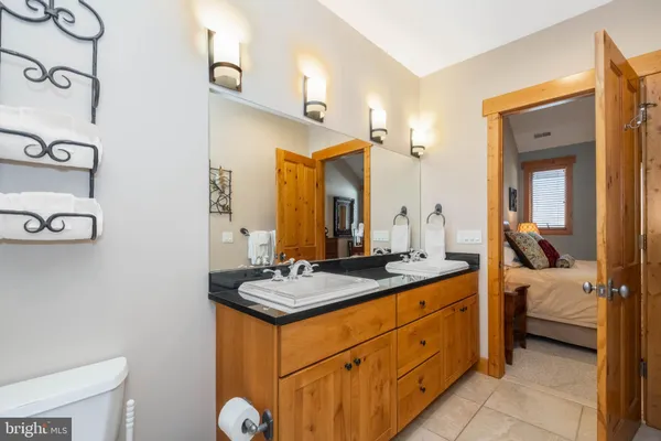 a en suite bathroom with a granite countertop sink and a mirror