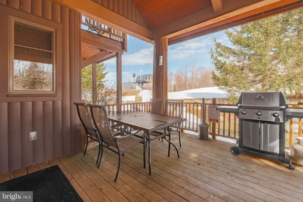 a view of a patio with table and chairs with wooden floor and fence