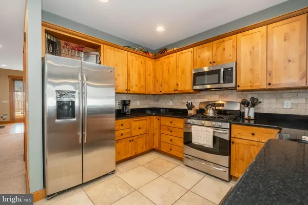a kitchen with stainless steel appliances granite countertop a stove a sink and a refrigerator