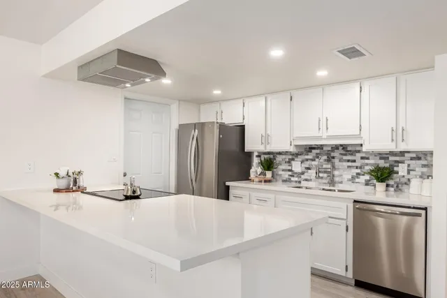 a kitchen with stainless steel appliances kitchen island granite countertop a sink stove and refrigerator