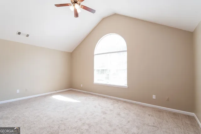 an empty room with a window and a ceiling fan