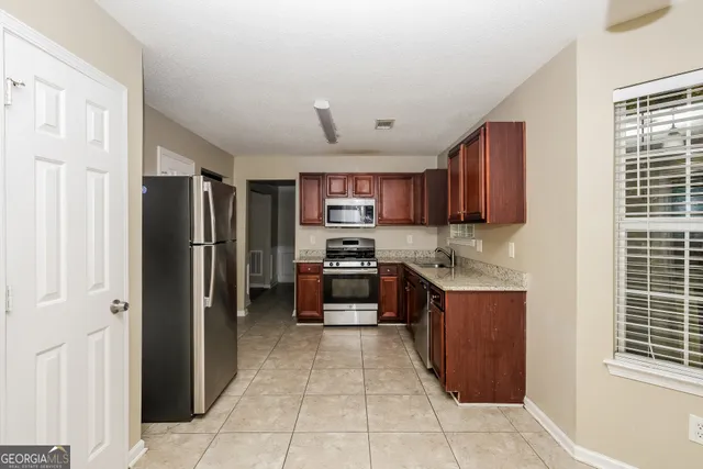 a kitchen with granite countertop a refrigerator and a stove top oven