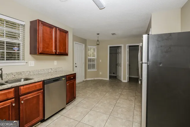 a kitchen with stainless steel appliances granite countertop a refrigerator and a sink