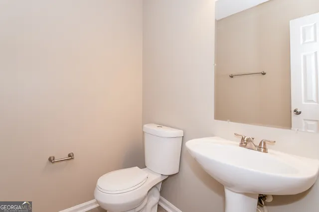 a bathroom with a sink a toilet and mirror