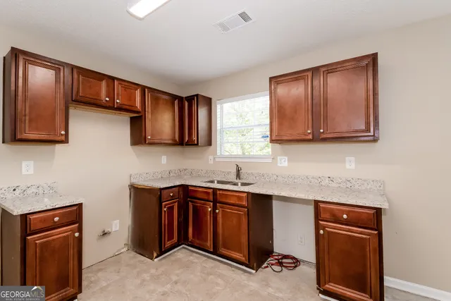 a kitchen with stainless steel appliances granite countertop wooden cabinets a stove top oven a sink and dishwasher
