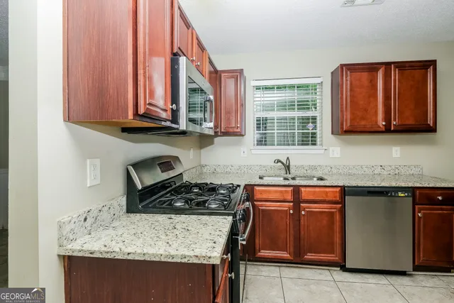 a kitchen with stainless steel appliances granite countertop a stove sink and cabinets