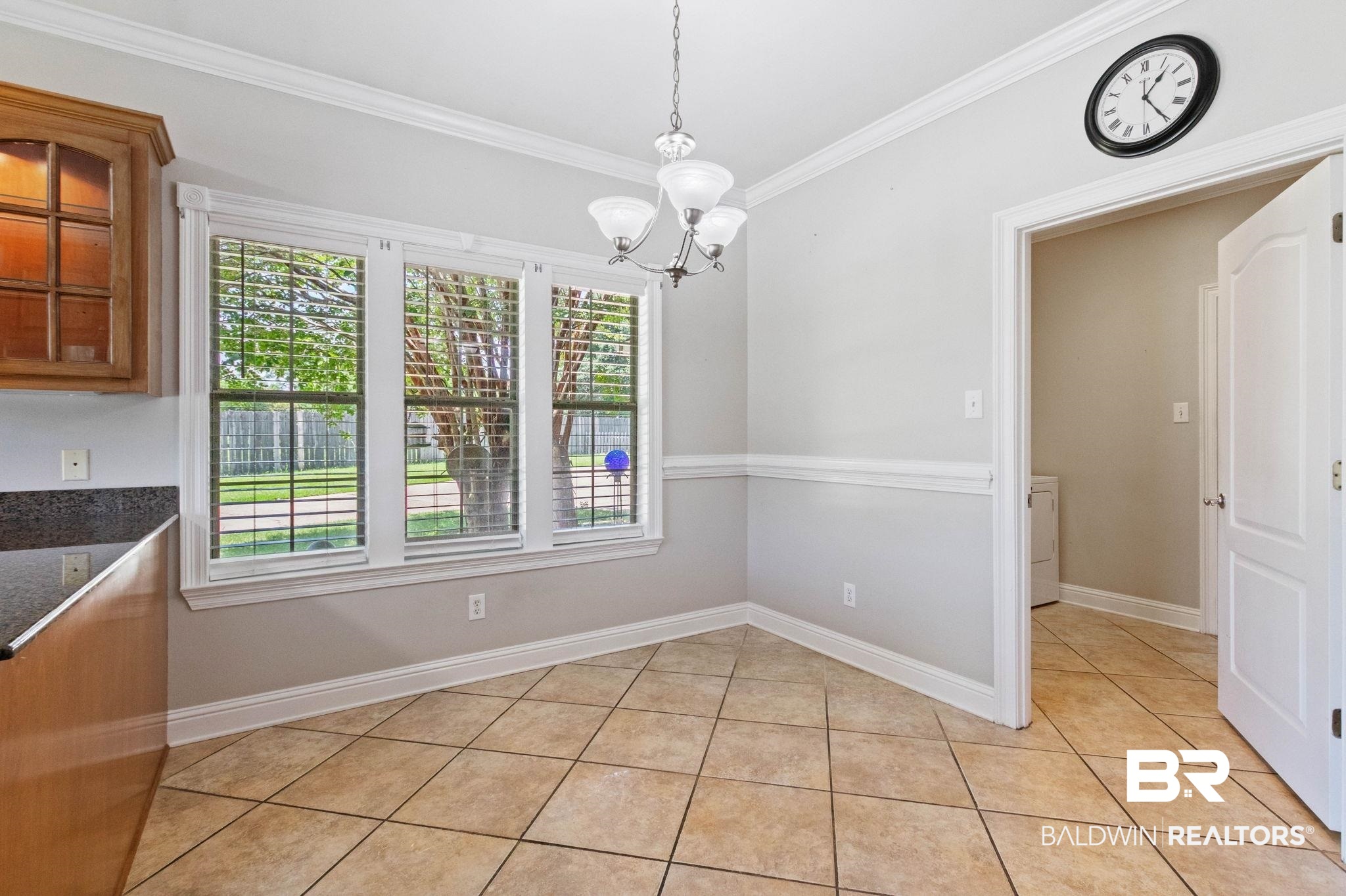 3176 Cedar Court Mobile, AL 36619 - Photo 12 of 33 Dining area featuring three large windows with horizontal blinds, neutral-toned tile flooring, and crown molding